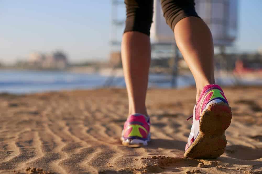 Imagem de tênis de correr na areia ilustra post sobre vantagens de ter uma casa na praia