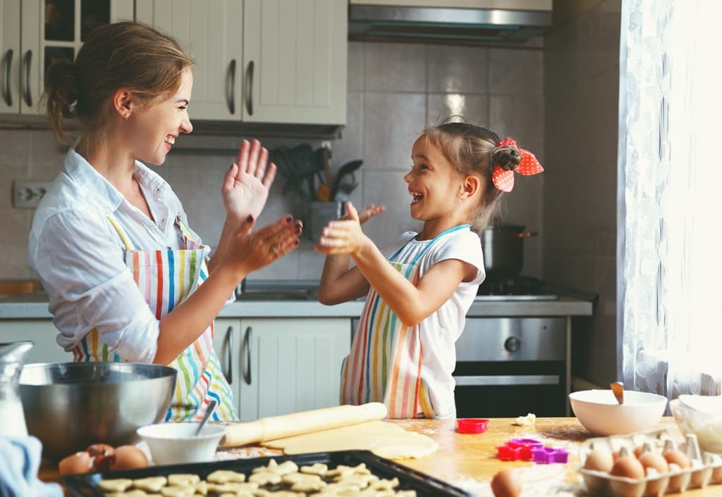 Imagem com mâe e filha cozinhando ilustra post sobre como manter as crianças entretidas dentro de casa, do blog da Soma Urbanismo
