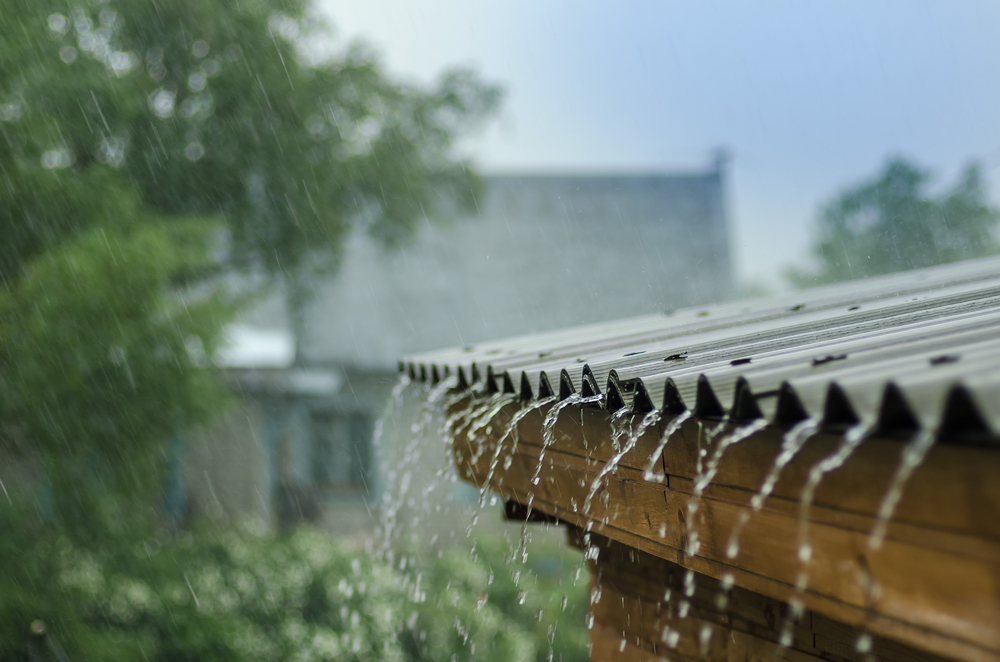 Foto de chuva caindo nas calhas do telhado para ilustrar o texto sobre captação de água da chuva do blog da Soma Urbanismo.