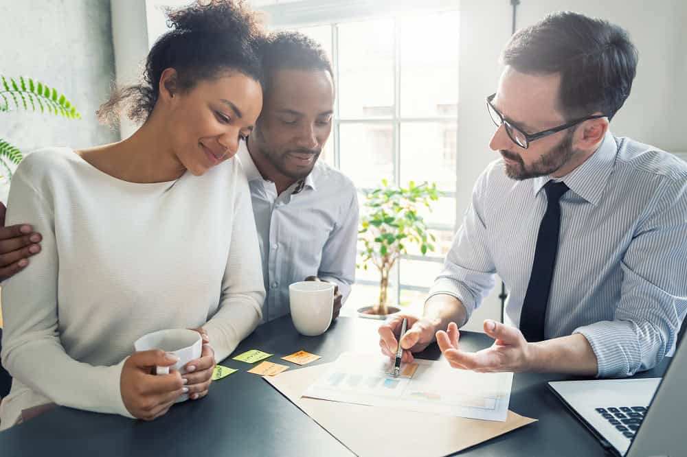 Corretor de imóveis conversa com casal. Imagem ilustrativa para post sobre técnicas de persuasão para corretores.