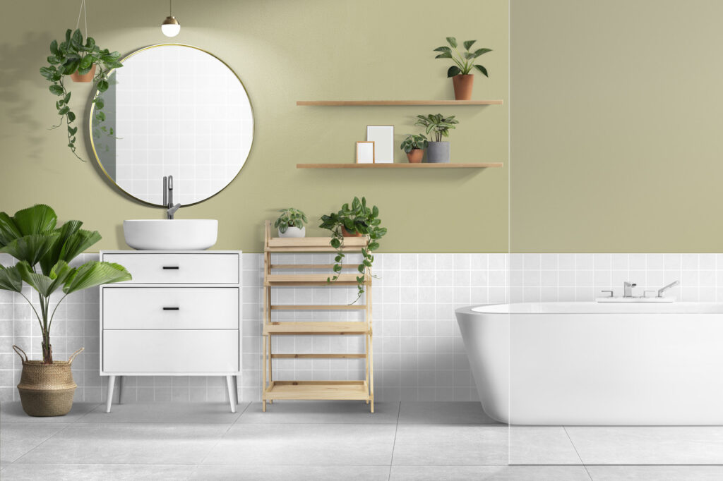 Foto de um banheiro decorado com prateleiras com plantas, espelho redondo, pia alta branca e banheira para ilustrar um texto sobre aproveitar o espaço no blog da Soma Urbanismo. 