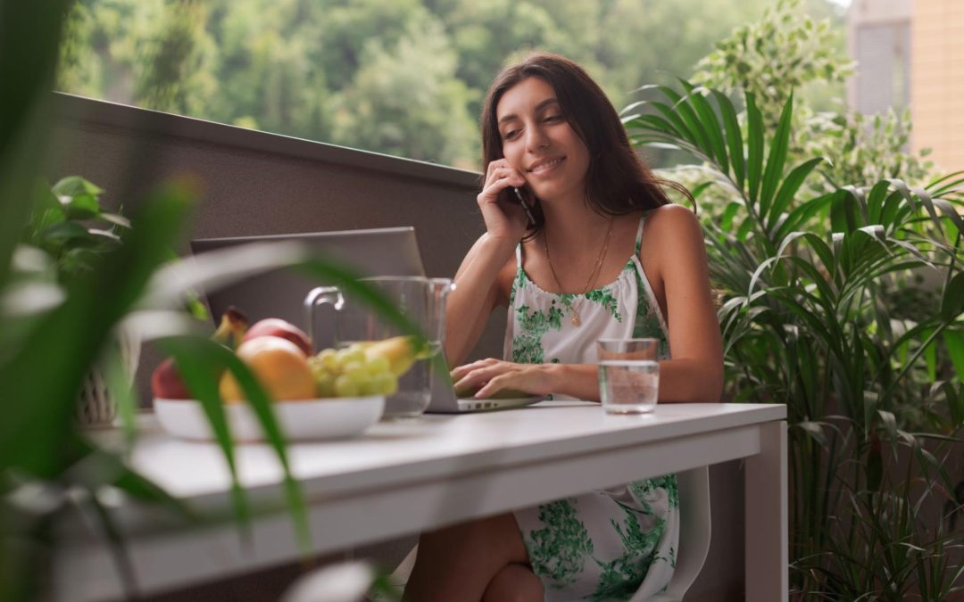 Mulher fala ao telefone em meio às plantas e frutas.