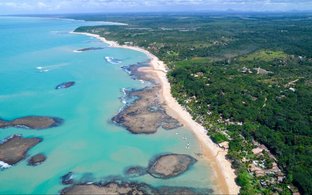 Visão aérea de praia de Porto Seguro. Imagem ilustrativa para post sobre o porquê de investir em um loteamento na cidade no ano de 2026, do blog da Soma Urbanismo.